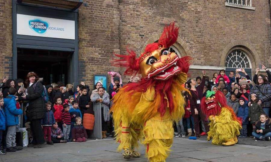 Families watch the Lion Dance outside the Museum of London Docklands
